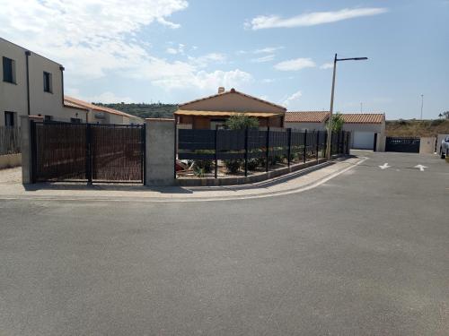 une clôture dans un parking avec un bâtiment dans l'établissement Chez Jacques, à Port-la-Nouvelle