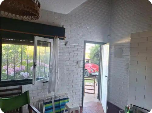 a room with a white brick wall and a window at Luminosa cercana a todo Promos increibles in La Pedrera