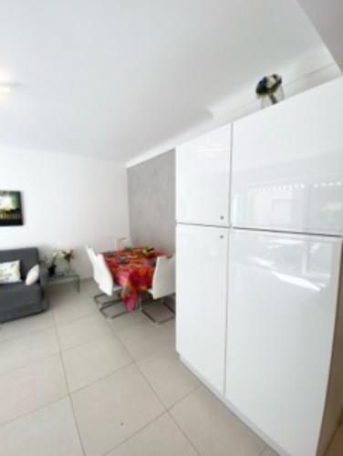 Il comprend une cuisine blanche équipée d'un réfrigérateur et d'un canapé. dans l'établissement One bedroom behind Martinez, à Cannes