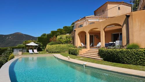une maison avec une piscine devant une maison dans l'établissement Charmante Luxusvilla vue de rêve, aussergewöhnlich großer Pool, Meerblick, à Théoule-sur-Mer