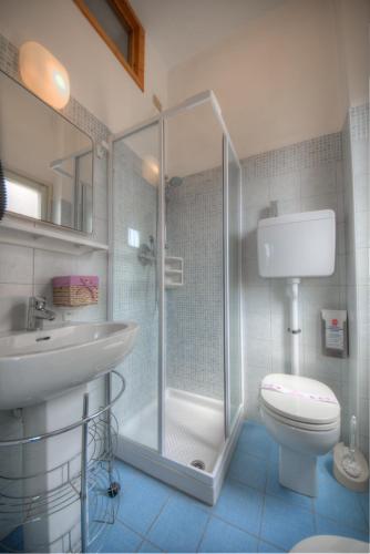 a bathroom with a shower and a toilet and a sink at Hotel Deutsche Familien in Finale Ligure
