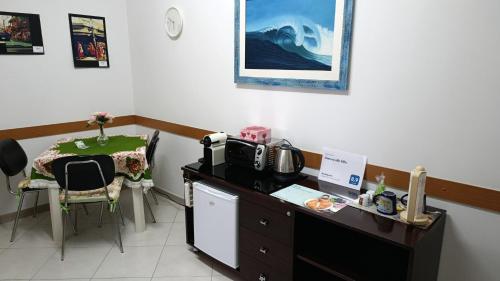 a room with a desk with a microwave and a table at Dimora alla Villa in Ostuni