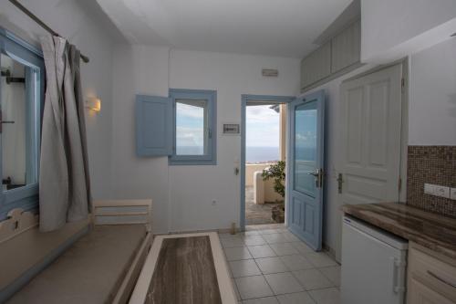 a kitchen with a blue door and a view of the ocean at Erato Apartments in Firostefani