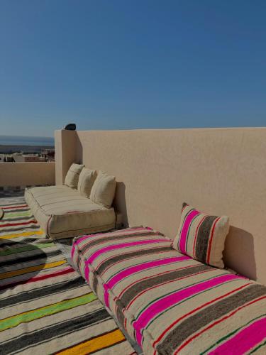 a living room with a couch and a rug at Playa Surf House in Tamraght Ouzdar