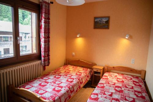 une chambre avec deux lits et une fenêtre dans l'établissement Appartement 6 pers Chalet Tournier, aux Gets