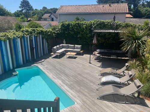 - une piscine avec des chaises, un canapé et une table dans l'établissement Villa 250m from beach, Moulleau village Arcachon, à La Teste-de-Buch