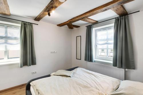 a bedroom with a bed and two windows at Zeihäänger Stubb in Schwalmstadt