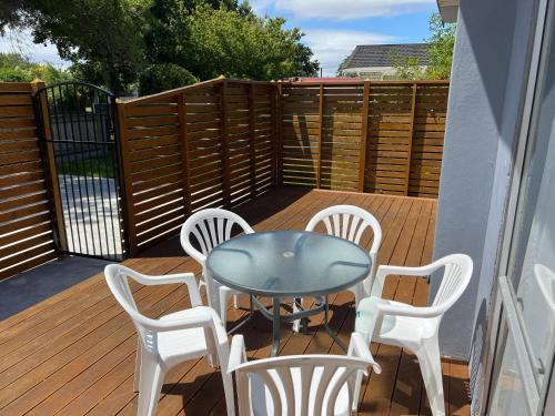 a patio with a table and chairs on a deck at Palmy Hideaway - Dog Friendly in Palmerston North