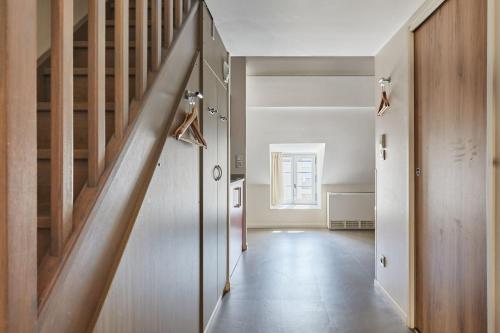 a hallway with a wooden staircase in a house at Appart'hôtel Odalys City - Dijon Centre Les Cordeliers in Dijon