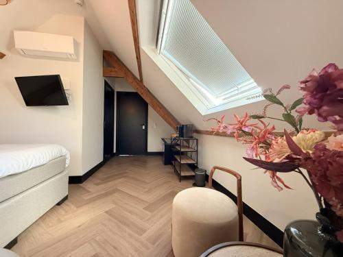 a attic room with a bed and a skylight at Herbergh Rehoboth in Heelsum