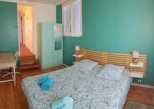 - une chambre avec un lit avec des draps bleus et une table dans l'établissement Villa 250m from beach, Moulleau village Arcachon, à La Teste-de-Buch
