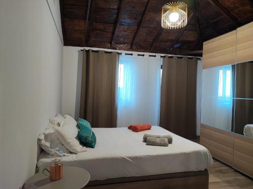 PuntallanaにあるCasa de campo con vistas al marのベッドとテーブルとシャンデリアのある寝室