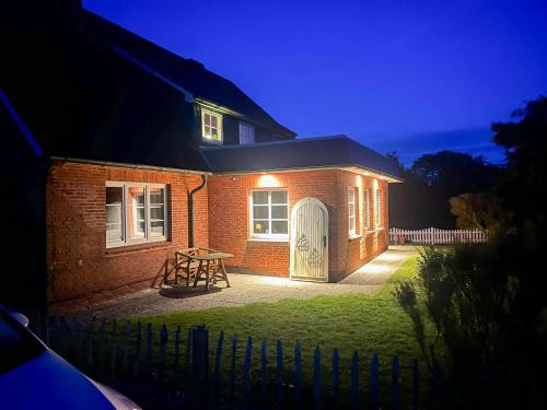 a brick house with a table in front of it at Hallig Hüs 2 in Langeneß