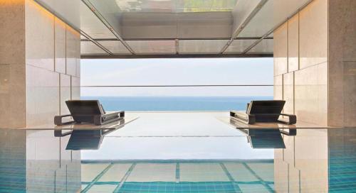 deux chaises assises sur une table dans une piscine dans l'établissement BBnB Home - Mai's House, à Quy Nhơn