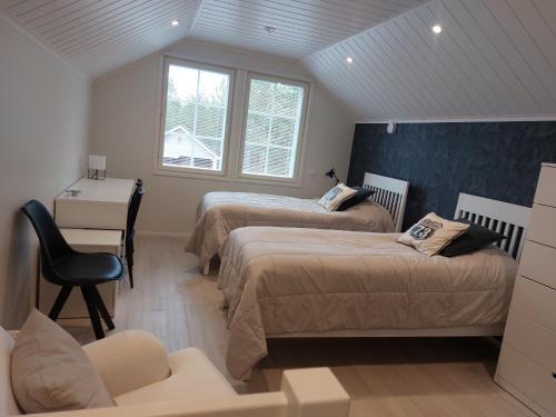 a bedroom with two beds and a desk and a chair at Kuukkeli in Kalajoki