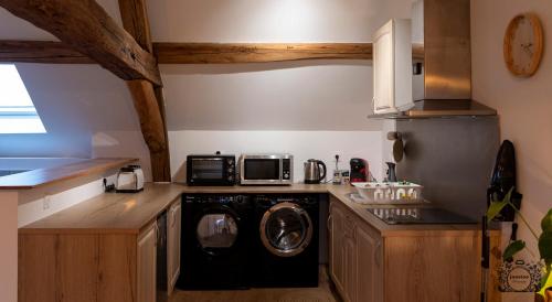 une cuisine avec un lave-linge et un micro-ondes dans l'établissement Joli appartement Cosy, à Nogent-sur-Seine