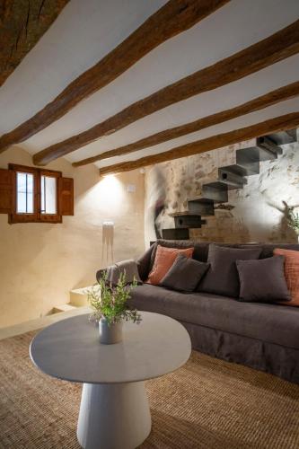 a living room with a couch and a table at Mas Grimosach - Masía en finca y bodega ecológica - Adults Only in Sant Pau dʼOrdal