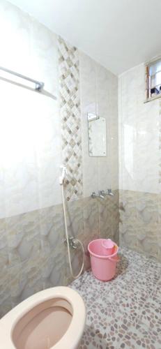 a bathroom with a toilet and a pink bucket at SHI's Kurunji 5BHK Villa in Pollachi in Pollāchi