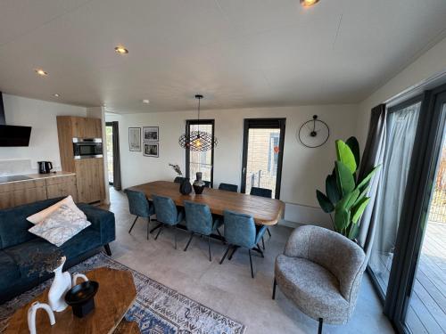 a living room with a dining room table and chairs at Enkhuizer Strand BeachHouse Deck Acht mit Zaun Nr 408 in Enkhuizen