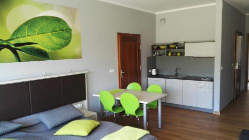 a kitchen and dining room with a table and green chairs at Catalpa Camp Ośrodek Rekreacyjno-Wypoczynkowy nad jeziorem Gopło in Piotrków Kujawski