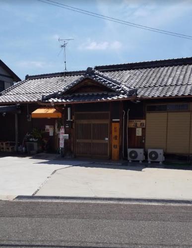 a house with two garage doors and a roof at 民泊優雅 in Izumi-Sano