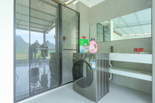 - un lave-linge dans la salle de bains pourvue d'une fenêtre dans l'établissement Yangshuo Soul Resort-Beside Yulong River, à Yangshuo