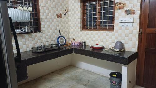 a kitchen with a counter top in a room at SHI's Kurunji 5BHK Villa in Pollachi in Pollāchi