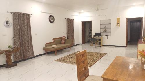 a living room with a couch and a table at SHI's Kurunji 5BHK Villa in Pollachi in Pollāchi