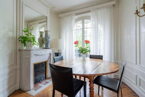une salle à manger avec une table et des chaises et une cheminée dans l'établissement Veeve - Père-Lachaise Chronicles, à Paris