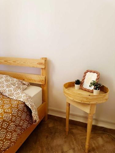 a table with plants on it next to a bed at Surf Treasure Morocco in Aourir