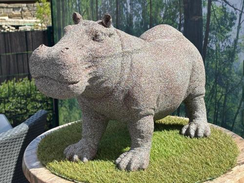 a statue of a hippopotamus standing on some grass at Ambiente Hotel Strehla in Strehla