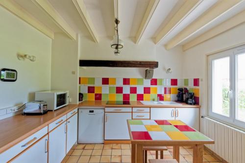 - une cuisine avec du carrelage coloré sur le mur dans l'établissement Gite Entre Mer Et Golf, à Plourhan