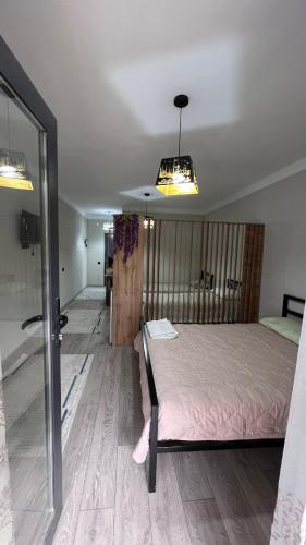a bedroom with a bed and a sliding glass door at Уют у озера IK Ayar House in Cholpon-Ata