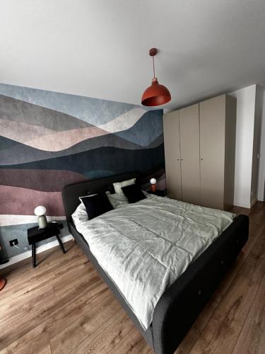 a bedroom with a large bed with a painting on the wall at PURA Vida in Gdynia