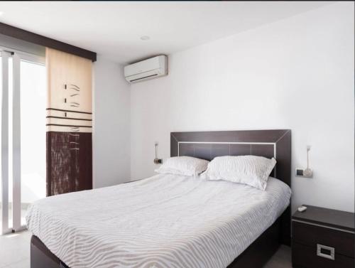 カルプにあるRIURAU HOME - 1ª línea CalpeMarの白いシーツが敷かれた大きなベッドのある寝室