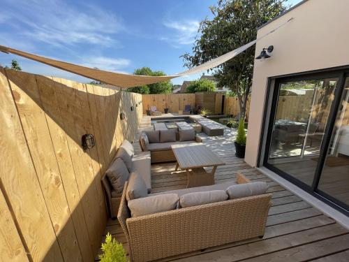 un patio avec des canapés et une table sur une terrasse dans l'établissement Le Gite Hector, à Carcassonne