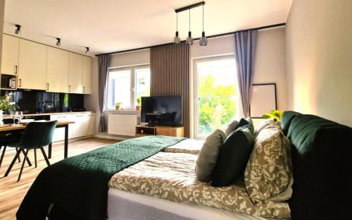 Cet appartement comprend une chambre avec un lit, une cuisine et une table. dans l'établissement Elite Home 1 Jeżyce- Barańczaka 1, à Poznań