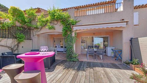 a patio with a pink table and chairs on a wooden deck at CASA SELLA Beautiful terrace with Sea View in Sainte-Maxime