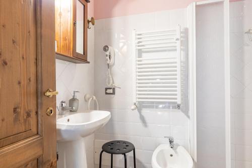 a white bathroom with a sink and a toilet at Masseria del bosco Poderuccio in Chianciano Terme