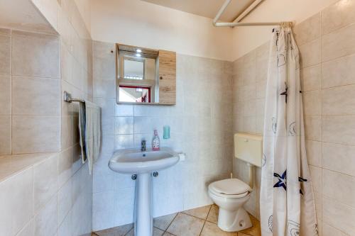 un baño con lavabo e inodoro en Villetta Orizzonte vista mare, en Patù