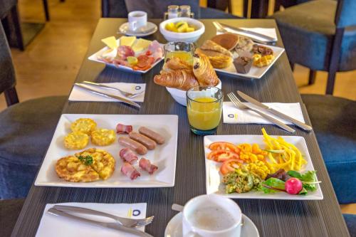 Una mesa con tres platos de comida encima. en Marmotel & Spa, en Pra-Loup