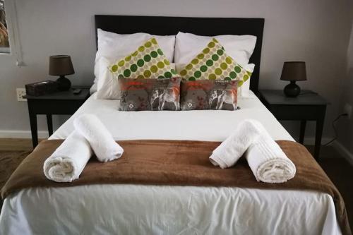 a bedroom with a bed with two towels on it at Caesar's Self-catering Open Plan Suite in Somerset West