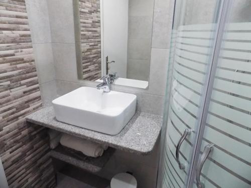 a bathroom with a white sink and a shower at Anemos Studios in Adamas