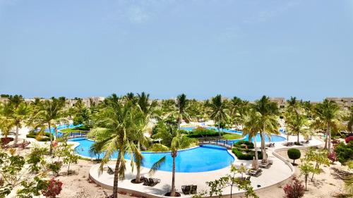 an aerial view of a resort pool with palm trees at Lux Villa Azure in Salalah