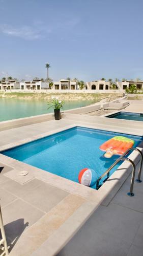 a swimming pool with blue water in a resort at Lux Villa Azure in Salalah