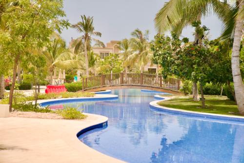 a swimming pool with a bridge in a resort at Lux Villa Azure in Salalah