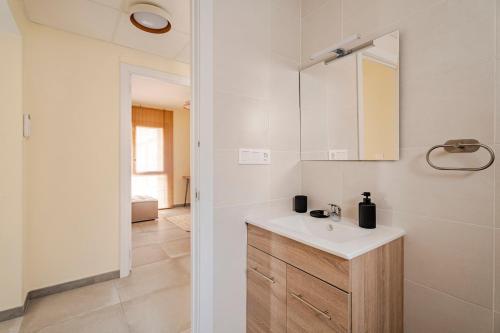 a white bathroom with a sink and a mirror at Chalet de lujo en Cala Lanuza con vistas al mar in El Campello
