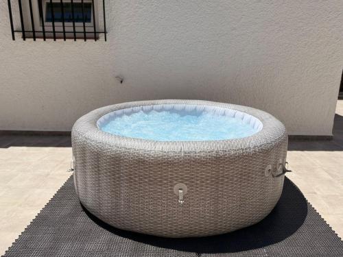 a large wicker bath tub sitting on a rug at Chalet de lujo en Cala Lanuza con vistas al mar in El Campello