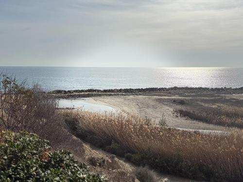 a sandy beach with the ocean in the background at Chalet de lujo en Cala Lanuza con vistas al mar in El Campello