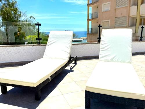two white chairs on a balcony with a view of the ocean at Chalet de lujo en Cala Lanuza con vistas al mar in El Campello